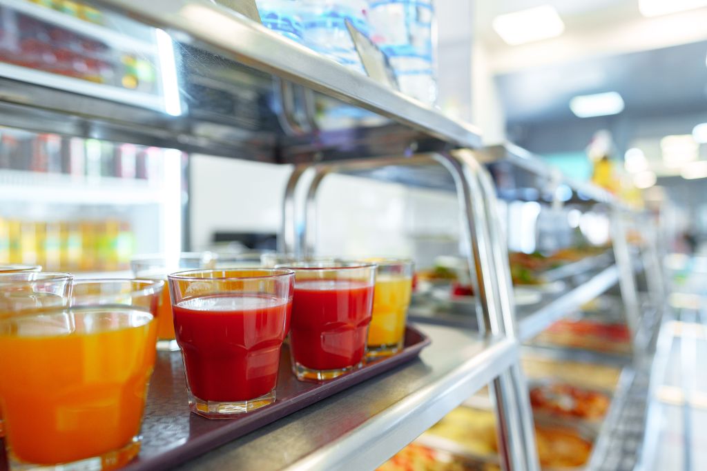Colorful Array of Fruit Juice Cups on a Serving Cart in a Cafeteria - KSDT • Accountants & Advisors