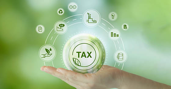 EnvironmentalTaxBreaksConceptHoldingGlassBallWithGreenTax